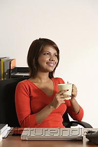 PictureIndia - Business woman holding coffee mug, smiling