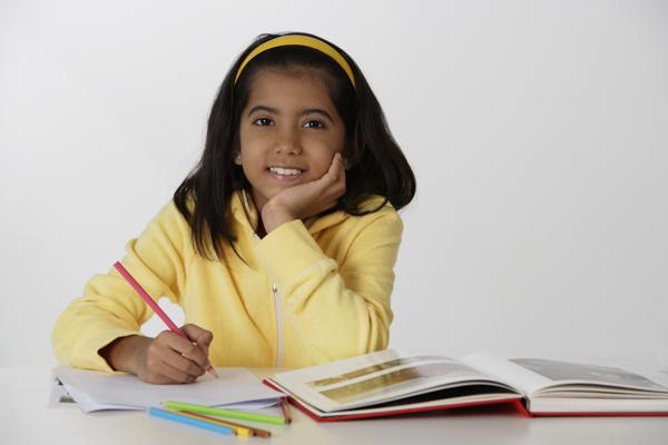 PictureIndia - Girl working with color pencils and book