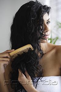 PictureIndia - Indian woman with bare shoulders and combing her hair.