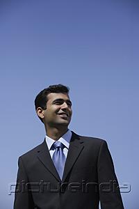 PictureIndia - Indian businessman smiling outside.