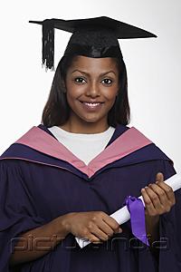 PictureIndia - Young woman wearing graduation cap and gown and holding diploma