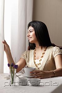 PictureIndia - woman sitting at cafe and looking out the window