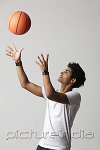 PictureIndia - young man throwing basketball into the air