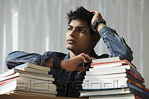 PictureIndia - young man with a stack of books thinking