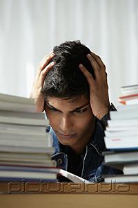 PictureIndia - young man holding head and reading book