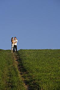 Mind Body Soul - Young couple embracing on top of hillside