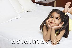 Asia Images Group - Girl lying on bed, resting on elbows