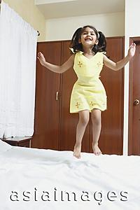 Asia Images Group - Girl jumping on bed