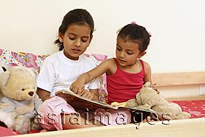 Asia Images Group - Sisters reading story book