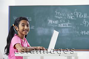 Asia Images Group - girl working at laptop, smiling at camera
