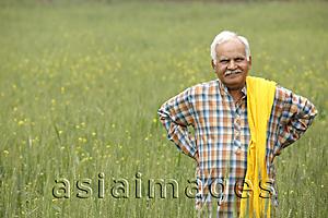 Asia Images Group - Farmer in field, hands on hips