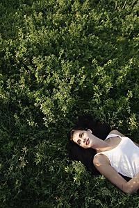 Mind Body Soul - Young woman lying on back in field