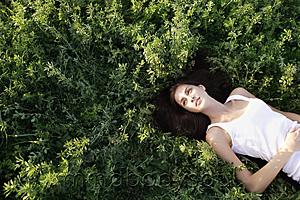 Mind Body Soul - Young woman lying on her back in field