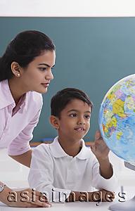 Asia Images Group - teacher and student look at globe
