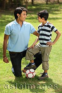 Asia Images Group - Father and son with foot on soccer ball