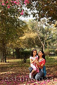 Asia Images Group - daughter sitting on mother's lap outdoors