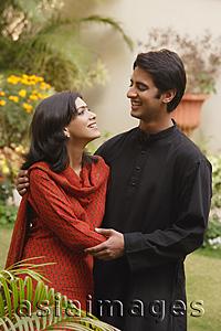 Asia Images Group - husband and wife in garden embracing, smiling at each other
