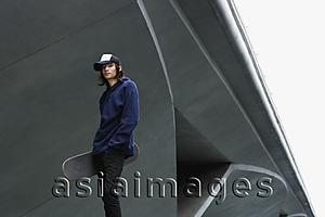 Asia Images Group - young man with skateboard, wearing cap