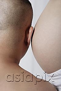 AsiaPix - Man leaning ear against pregnant stomach