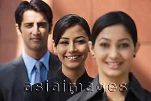 Asia Images Group - two businesswomen smiling at camera, one businessman (second woman in focus)