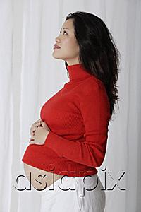 AsiaPix - Profile of pregnant woman with hands on stomach