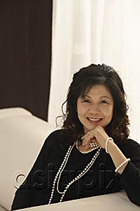 AsiaPix - elegant woman sitting on couch