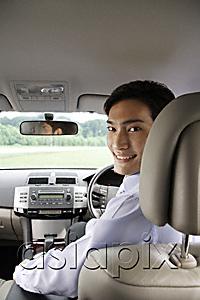 AsiaPix - Man driving car, looking back over shoulder