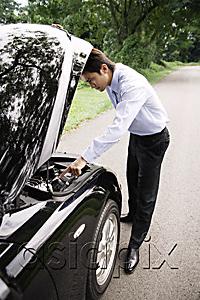 AsiaPix - Businessman looking under hood of car