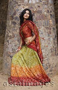 Asia Images Group - young woman in sari, stone pillar