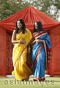 Asia Images Group - two women in saris in front of red tent