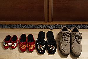 AsiaPix - top view of slippers and shoes placed in a row at door front