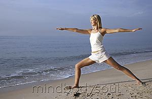 Mind Body Soul - woman doing yoga on the beach