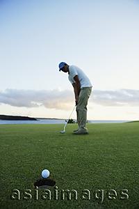 Asia Images Group - man playing golf during sunset