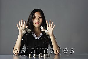 Asia Images Group - young lady throwing coins on table