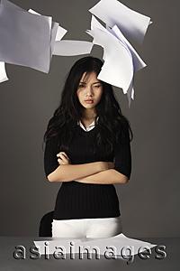 Asia Images Group - young lady standing, paper falling from above