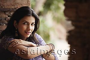 Asia Images Group - young woman in sari, sitting with arms folded