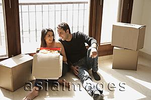 Asia Images Group - young couple in new home with moving boxes