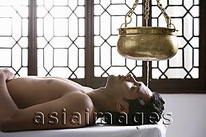 Asia Images Group - young man having Ayurvedic spa treatment