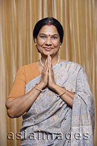 Asia Images Group - portrait of woman in namaste greeting gesture