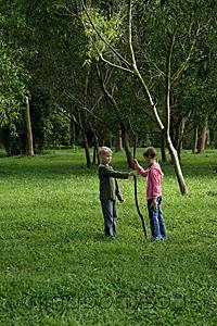 Mind Body Soul - boy and girl holding stick in field
