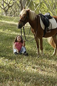 Mind Body Soul - Young girl sitting under pony, holding reigns