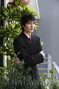 Asia Images Group - young man in suit, crossed arms