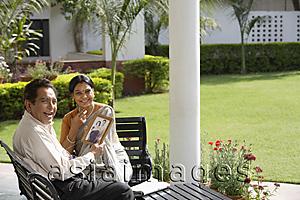 Asia Images Group - couple sitting outside, holding photograph