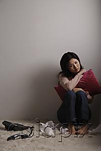 AsiaPix - Chinese woman sitting on floor looking sad