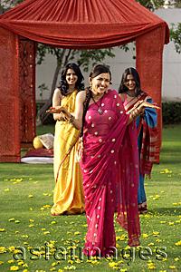 Asia Images Group - three young women wearing saris, in front of tent