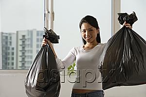 AsiaPix - Young Asian woman holding up trash bags
