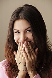 AsiaPix - young woman laughing while covering her mouth with her hands