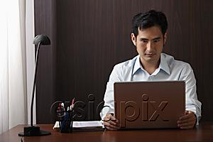 AsiaPix - man sitting at desk working on laptop