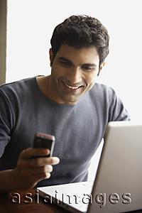 Asia Images Group - man looking at text messages