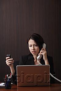 AsiaPix - Woman sitting at her desk multi-tasking